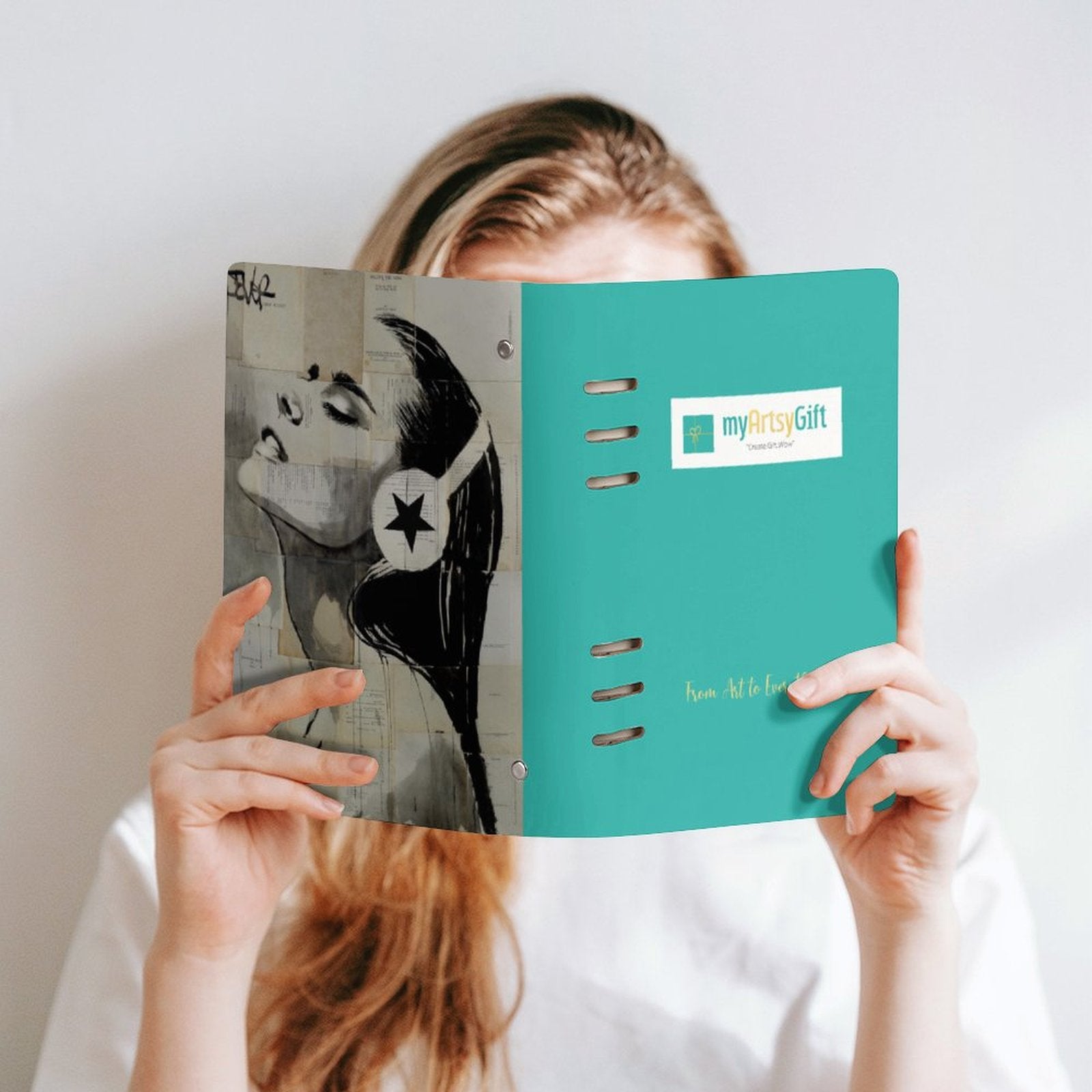 MyArtsyGift teal loose-leaf notebook held by a person, featuring an art print and 'From Art to Everything'