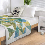 My Greenhouse Geo Lamb Wool Fleece Blanket on a bed, featuring geometric design and soft material, ideal for bed or couch.