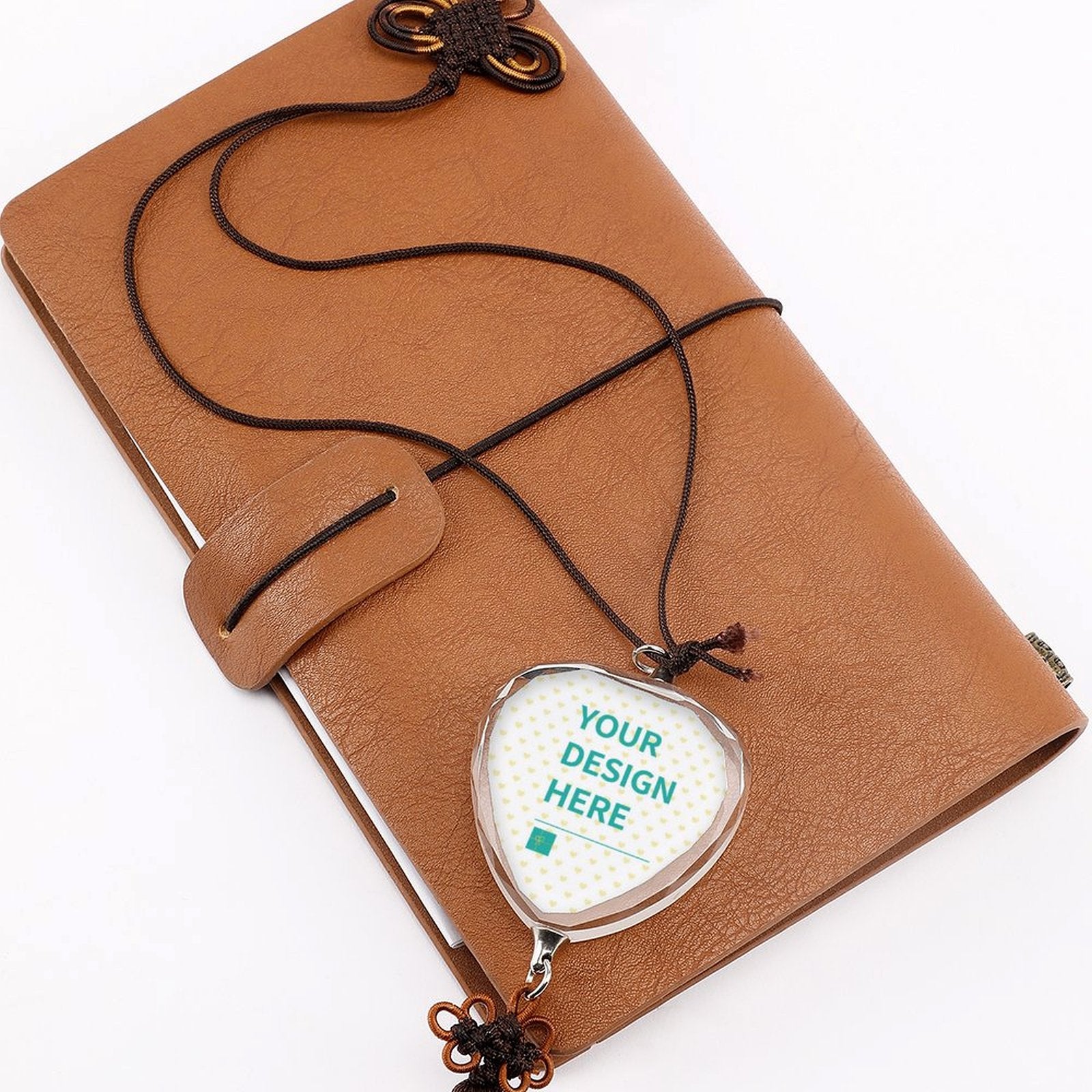 Personalized crystal car pendant with custom design area, glass heart shape, Chinese knot, tassel, and brown leather journal.