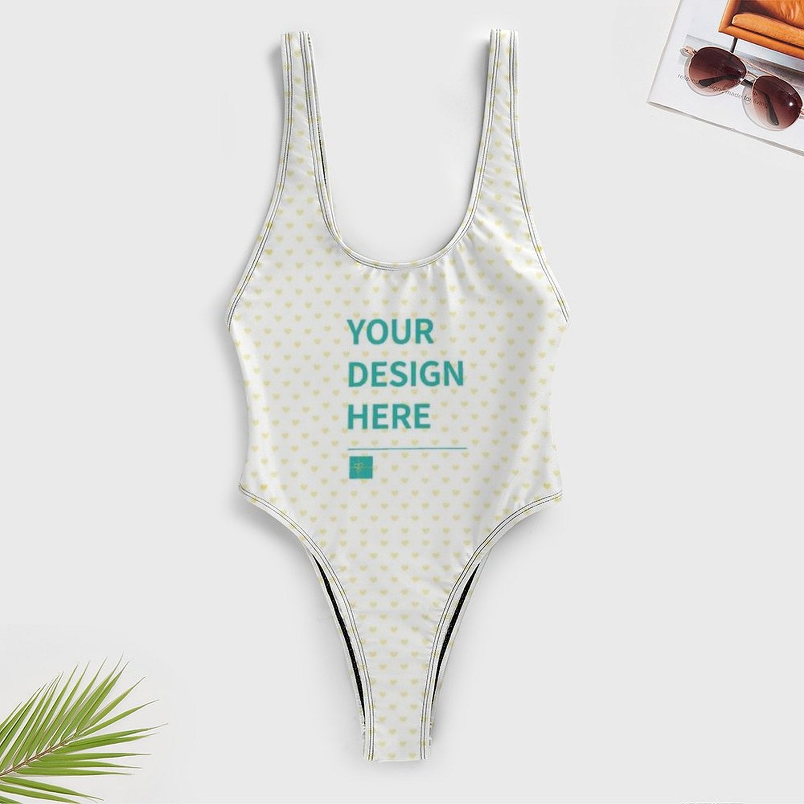 Customizable one-piece swimsuit for women with heart pattern, featuring 'YOUR DESIGN HERE'. Personalized swimwear.