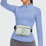 Custom fanny pack with 'YOUR DESIGN HERE' text, adjustable waist bag for travel and sports, worn by a woman in light blue.