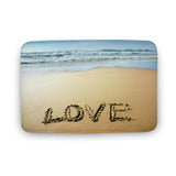 Coral velvet bath rug with a beach scene that says LOVE, non-slip and quick-drying.