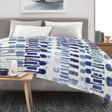 Modern blue abstract flannel blanket on bed, perfect for sofa, couch and bed. Made in USA, soft and cozy design.