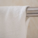 White polyester beach towel on metal bar, ideal for swimming and seaside use, soft and absorbent