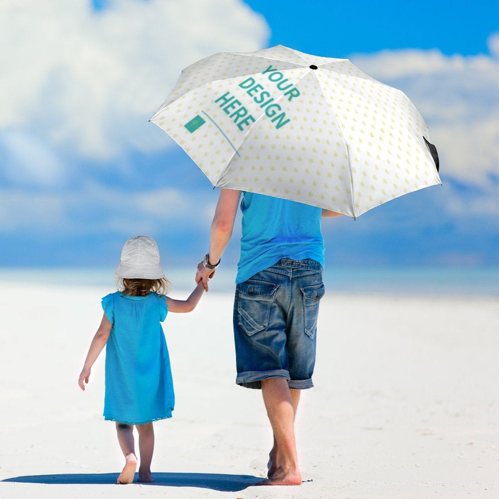 Customizable umbrella with "YOUR DESIGN HERE" text, walking on the beach, windproof and UV resistant gift.