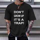 Black Gildan Unisex T-shirt with "DON'T GROW UP IT'S A TRAP!" print, comfortable cotton.