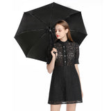 Woman holding black 3-fold umbrella, perfect for travel and outdoor activities, UV resistant, a stylish gift for women.