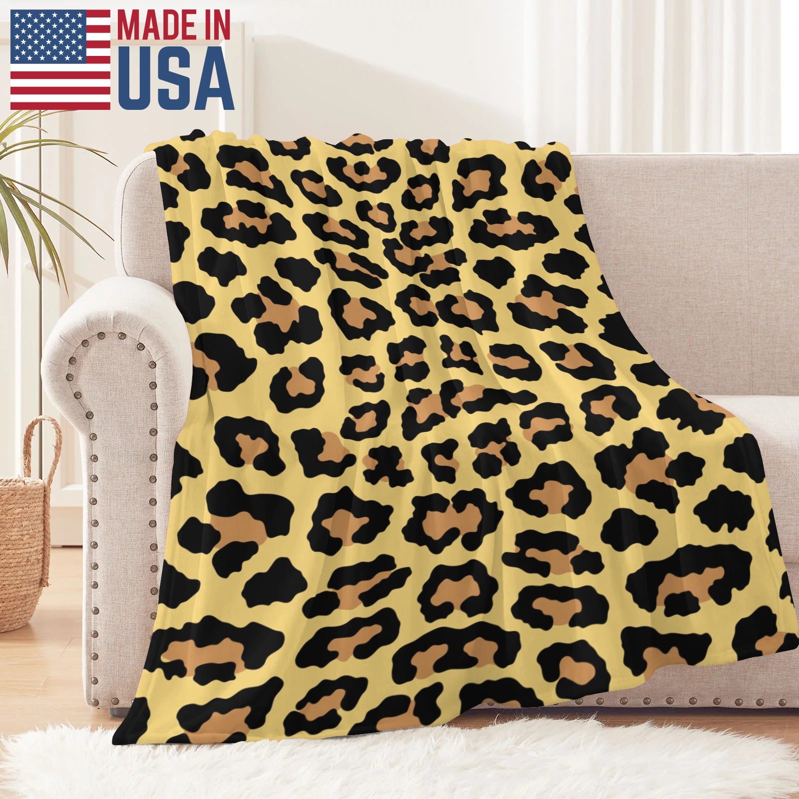 Leopard print flannel blanket made in USA, draped over a sofa, soft and warm for indoor and outdoor use.