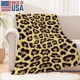 Leopard print flannel blanket made in USA, draped over a sofa, soft and warm for indoor and outdoor use.