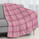 Pink buffalo plaid flannel blanket draped over a gray couch, home decor, USA made.