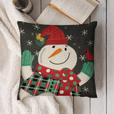 Christmas pillow cover featuring a smiling snowman in a red hat and scarf, green mittens, snowflakes; linen material.