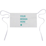 Customizable chef apron with text "YOUR DESIGN HERE". Apron is white, patterned, with pockets and ties.