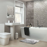 Coral velvet bath rug in bathroom with "The Adventure Never Ends" quote, non-slip and absorbent.