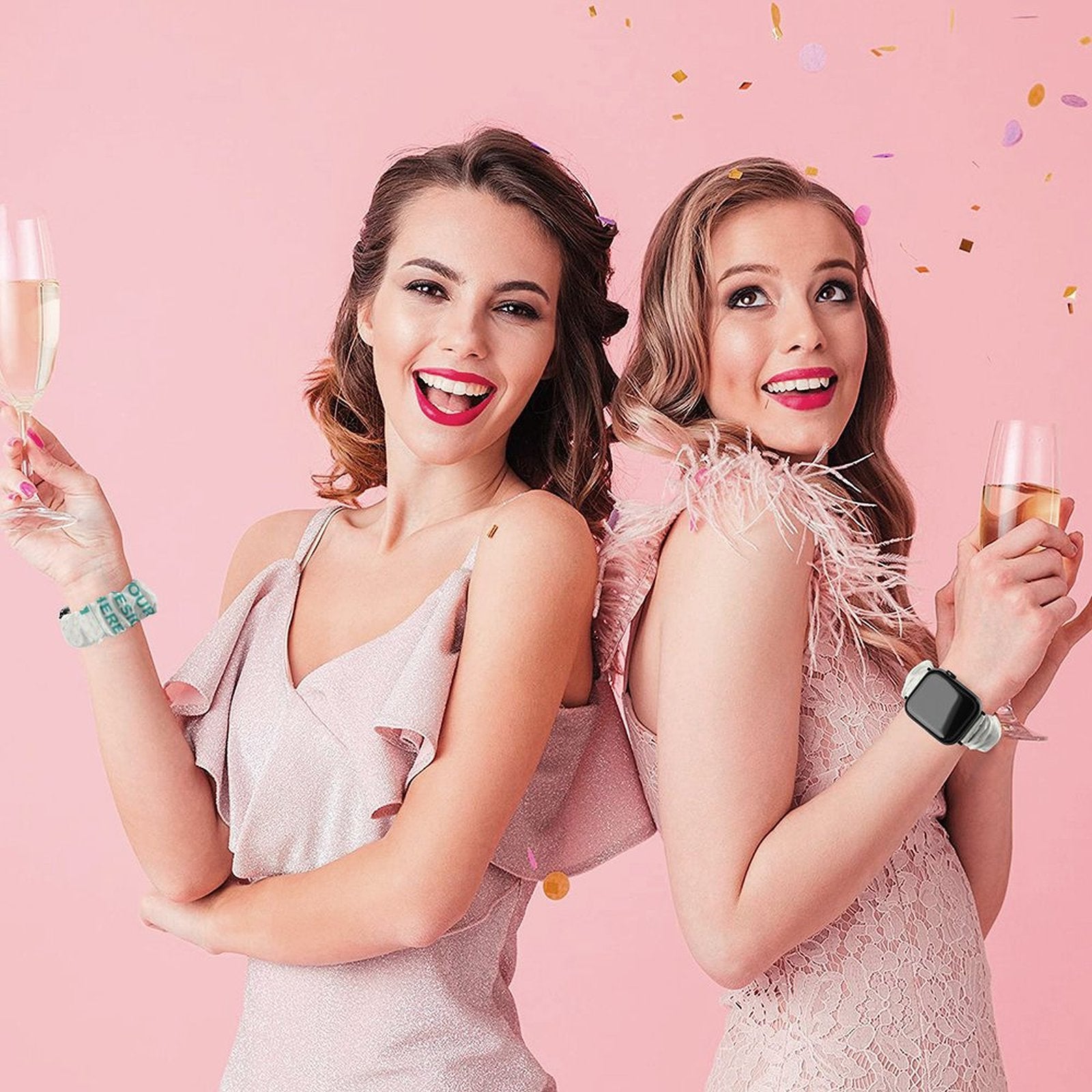 Two women wearing personalized Apple Watch bands with champagne, celebrating