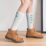 Customizable white knee-high socks with dotted pattern and 'YOUR DESIGN HERE' print, a perfect personalized Christmas gift.