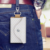 White PU leather keybag with yellow heart pattern, silver clasp, and snap closure. Leather key holder for keys and cards.