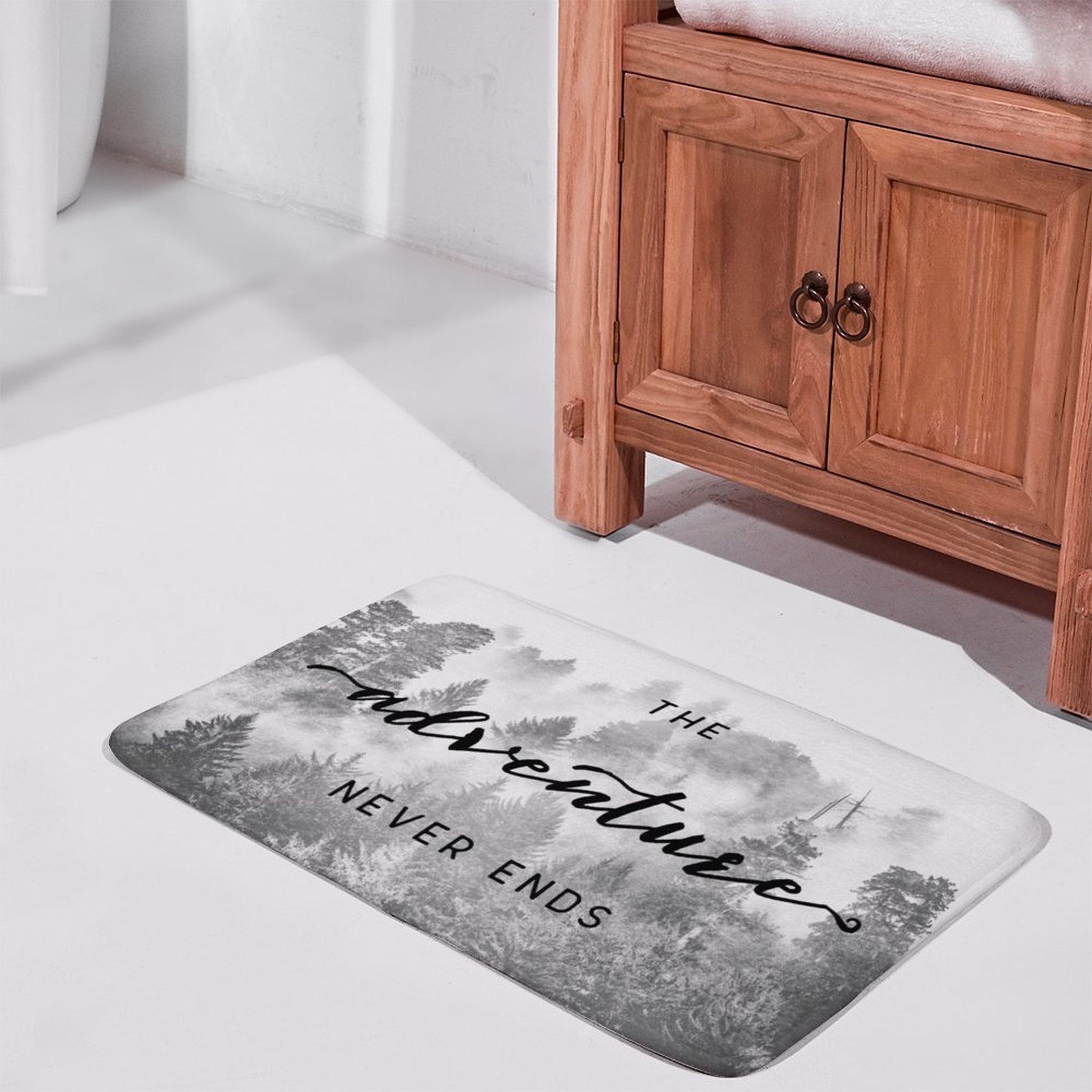 Coral velvet bath rug with "The Adventure Never Ends" design for bathroom