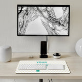 Customizable desk mat with 'YOUR DESIGN' text, keyboard, mouse, and a stylish office setup; a perfect personalized gift.