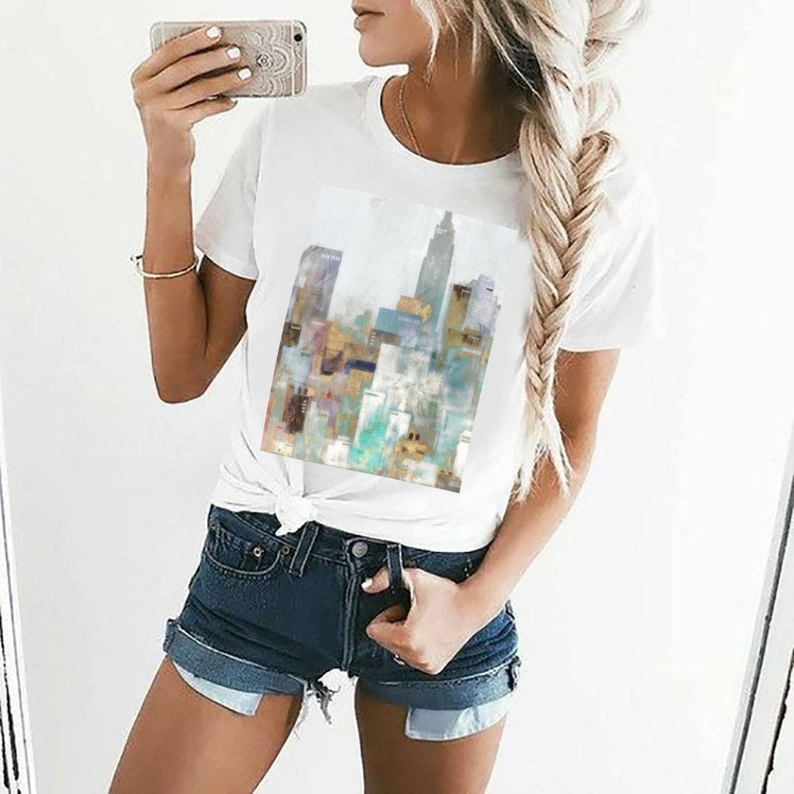 Women's white short sleeve crewneck t-shirt with abstract cityscape graphic print.