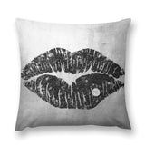 Black lip print pillow cover with diamond accent on a grey background.