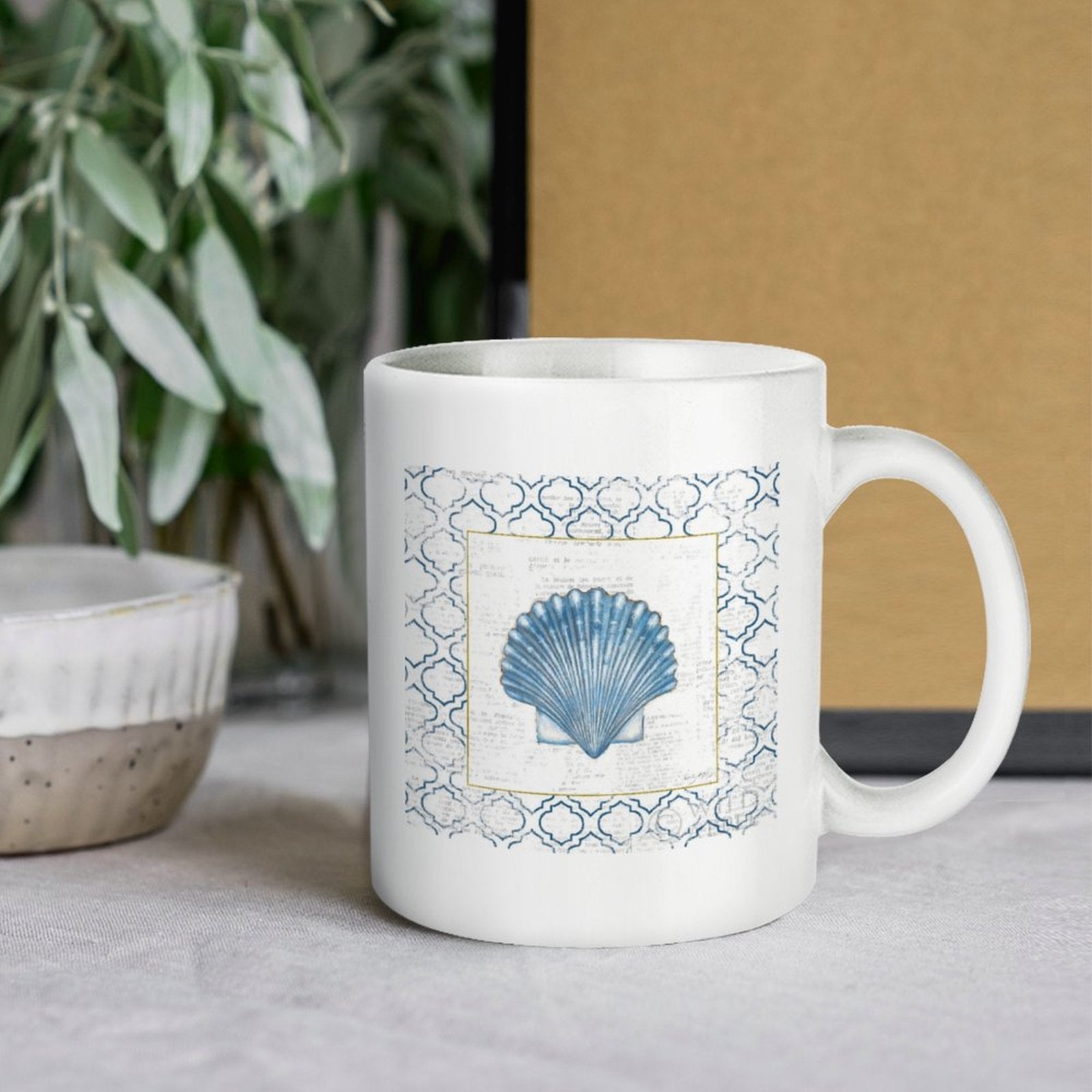 White ceramic coffee mug with blue seashell design; personalized gift