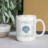 White ceramic coffee mug with blue seashell design; personalized gift