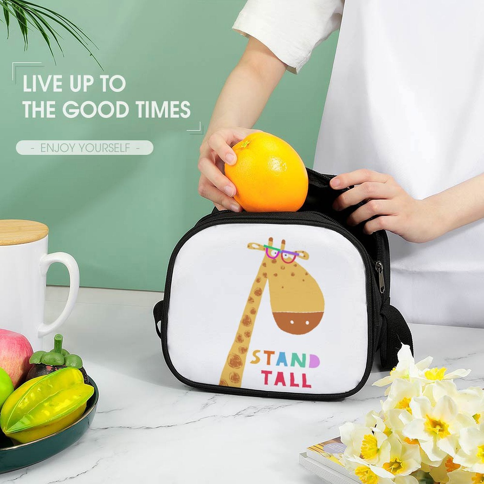 Kids' lunch bag with giraffe design and 'Stand Tall' message, holding an orange, MyArtsyGift product.