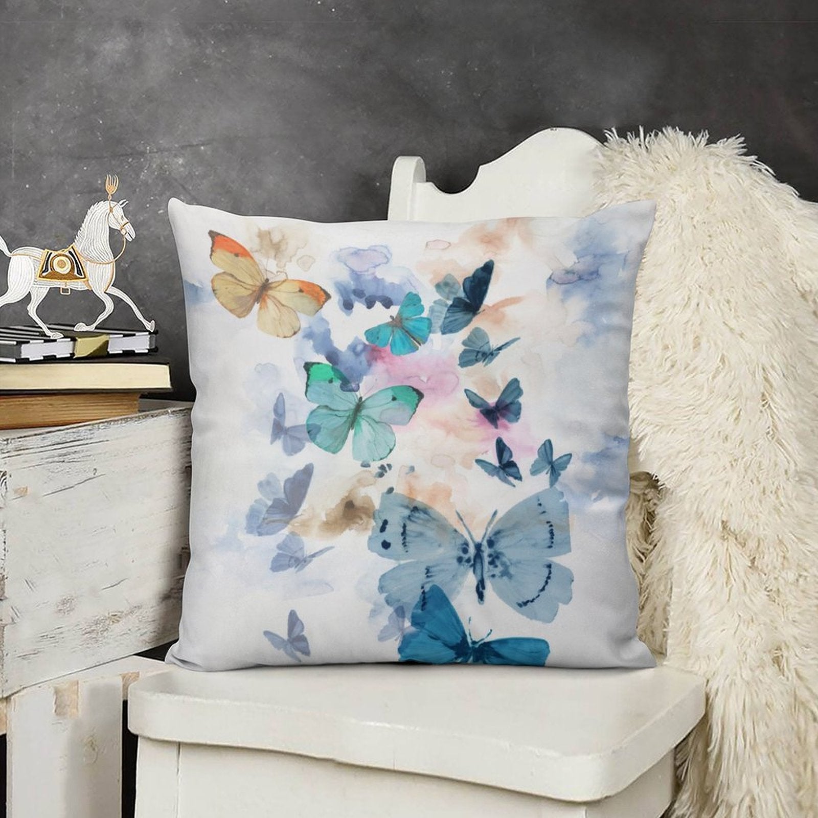Butterfly pillow cover for sofa decor. Soft plush pillow with blue, turquoise, and orange butterflies, white background.