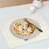 Heart pattern placemat with spaghetti and meatballs on a table setting. Personalized placemat for kitchen decor.