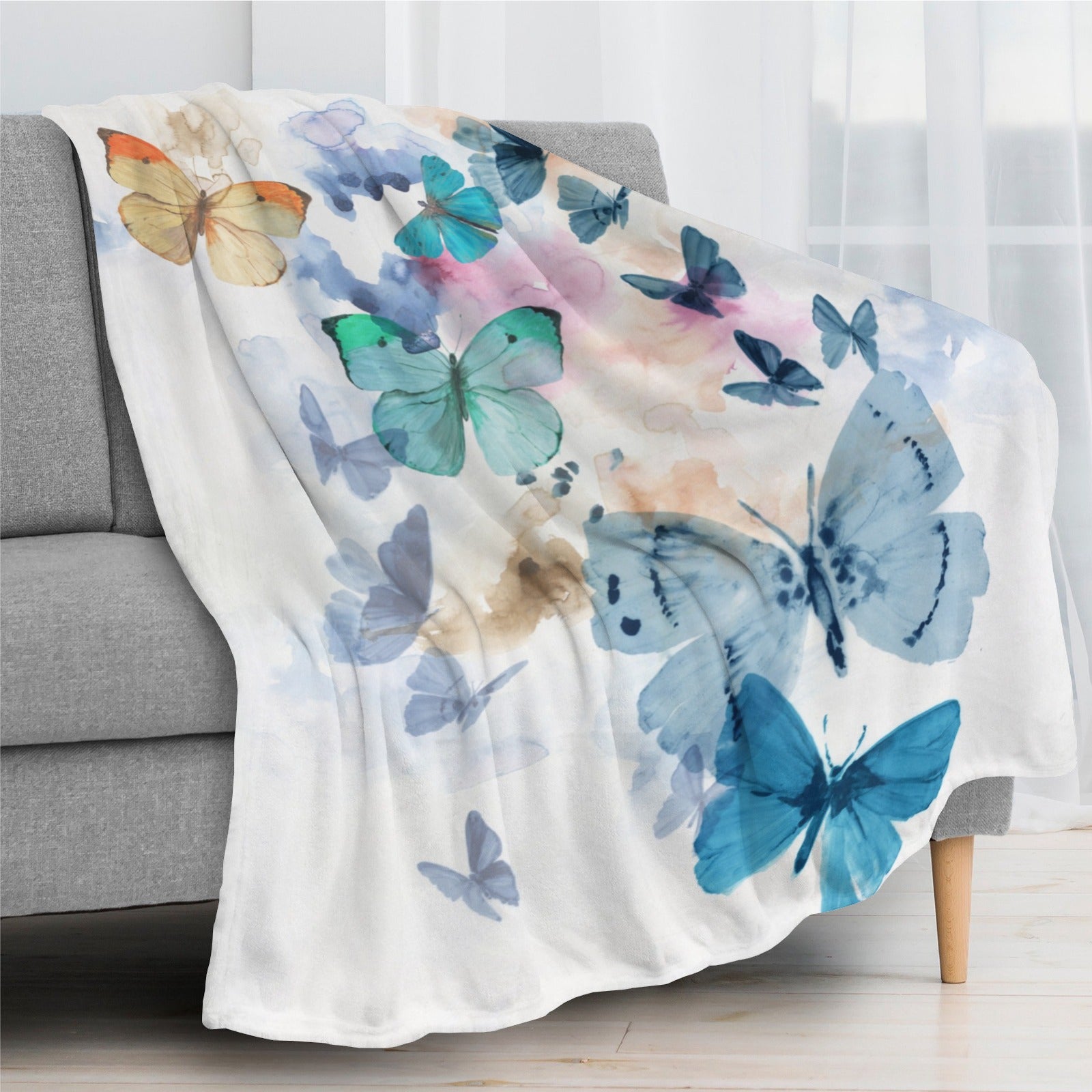 Blue butterflies flannel blanket on sofa, watercolor butterfly design, soft and cozy, made in USA