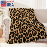 Leopard print flannel blanket, MADE IN USA, on a beige sofa. Soft, cozy, and perfect for home decor.