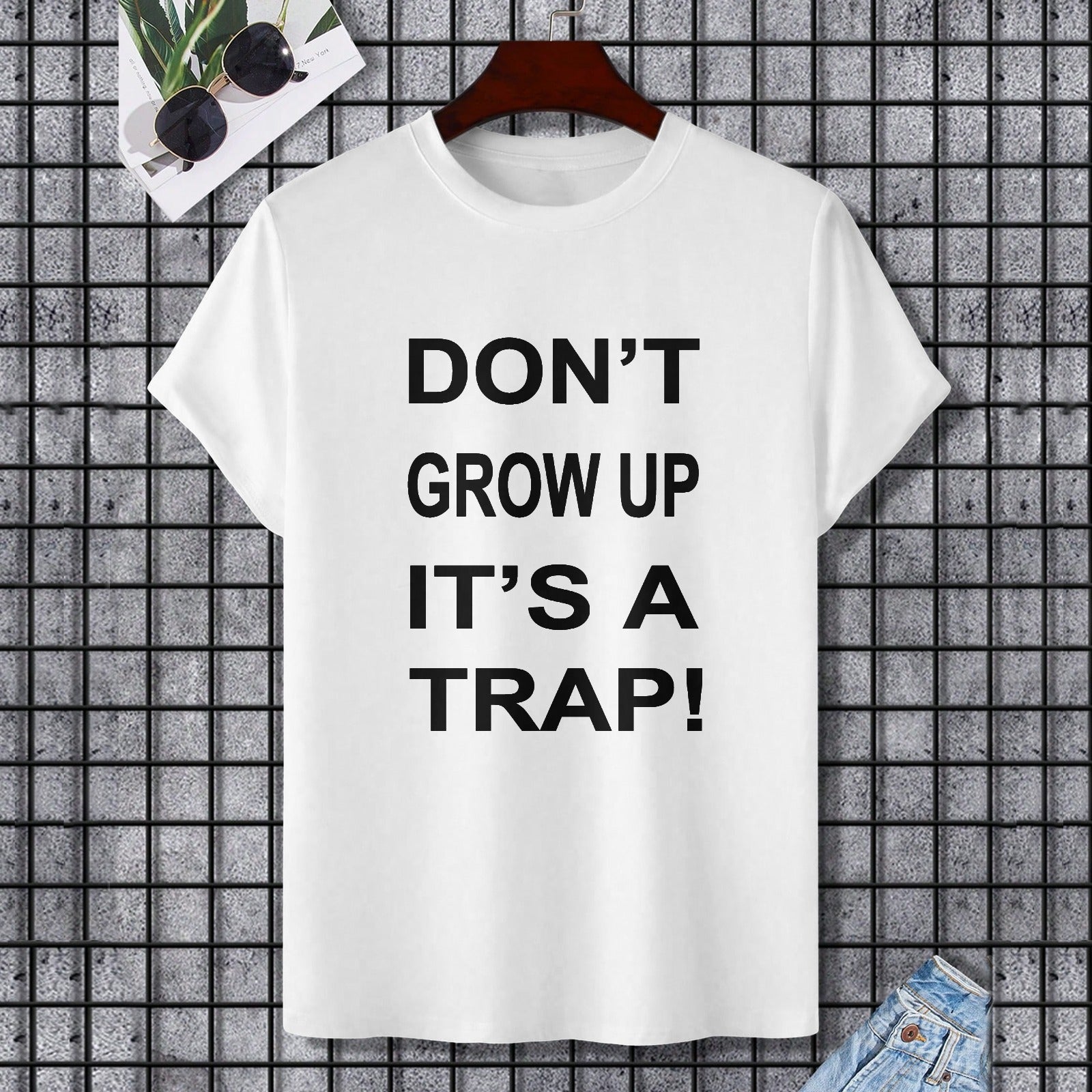 White Gildan unisex t-shirt with "DON'T GROW UP IT'S A TRAP!" print, perfect for casual wear.