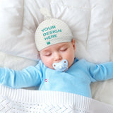 Custom baby beanie hat, white flannel, top knot design, personalized with "YOUR DESIGN HERE" on a sleeping baby.