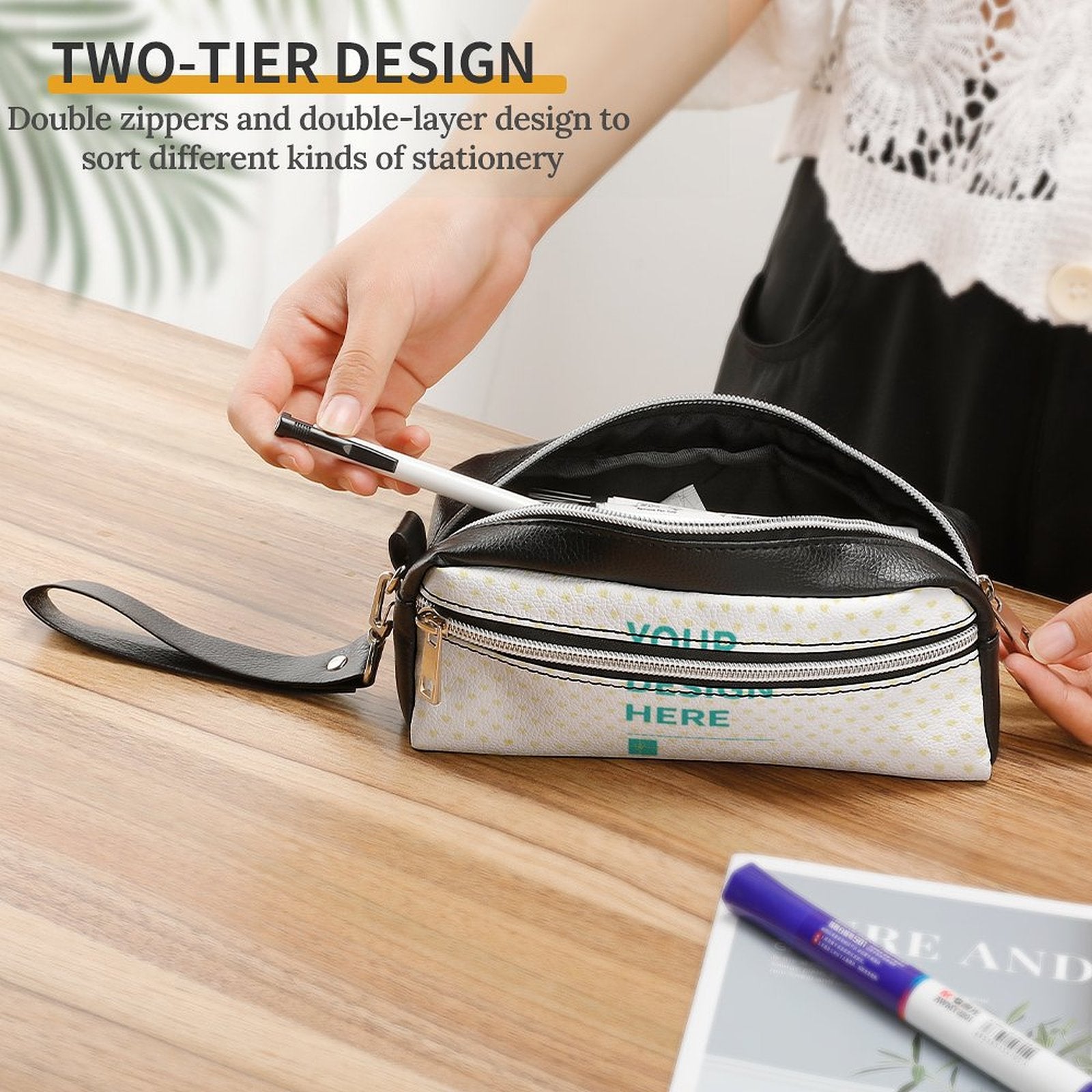 Two-tier personalized leather pen bag with double zippers, 'YOUR DESIGN HERE', for stationery, cosmetics, and office use.