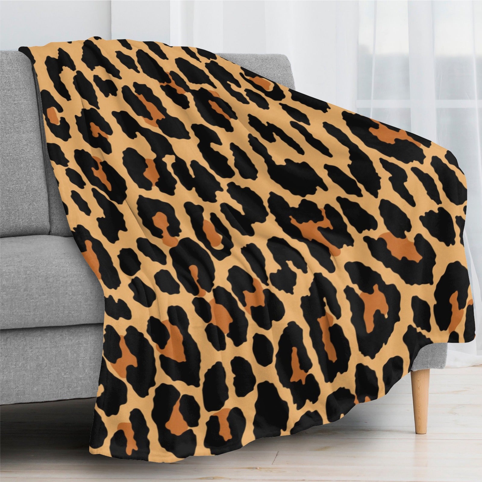 Leopard print flannel blanket on a sofa, soft and cozy.