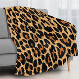 Leopard print flannel blanket on a sofa, soft and cozy.
