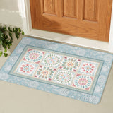 Blue floral door mat with a desert design, ideal for indoor or outdoor use, placed in front of a wooden door.