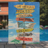 Metal tourist sign with city destinations like Los Angeles, Tokyo, New York. Rustic tin wall decor for home or office.