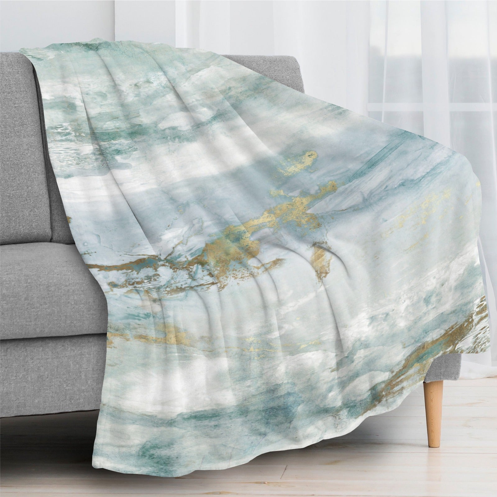 Green abstract flannel blanket draped over a sofa, watercolor design, perfect for bed or couch