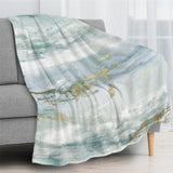 Green abstract flannel blanket draped over a sofa, watercolor design, perfect for bed or couch