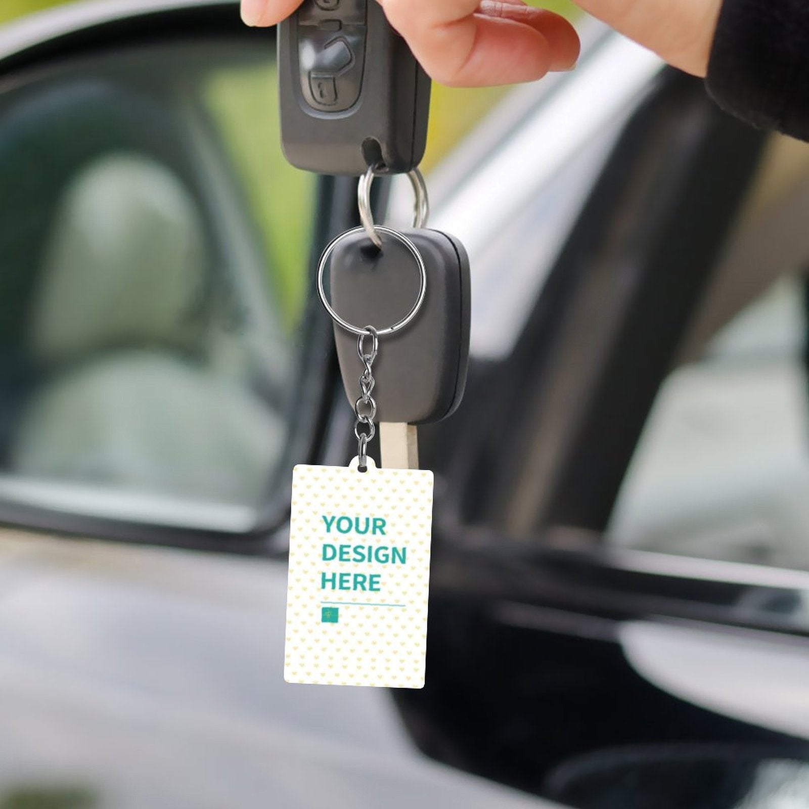 Personalized acrylic keychain with 'YOUR DESIGN HERE', perfect for customized gifts, attached to a car key
