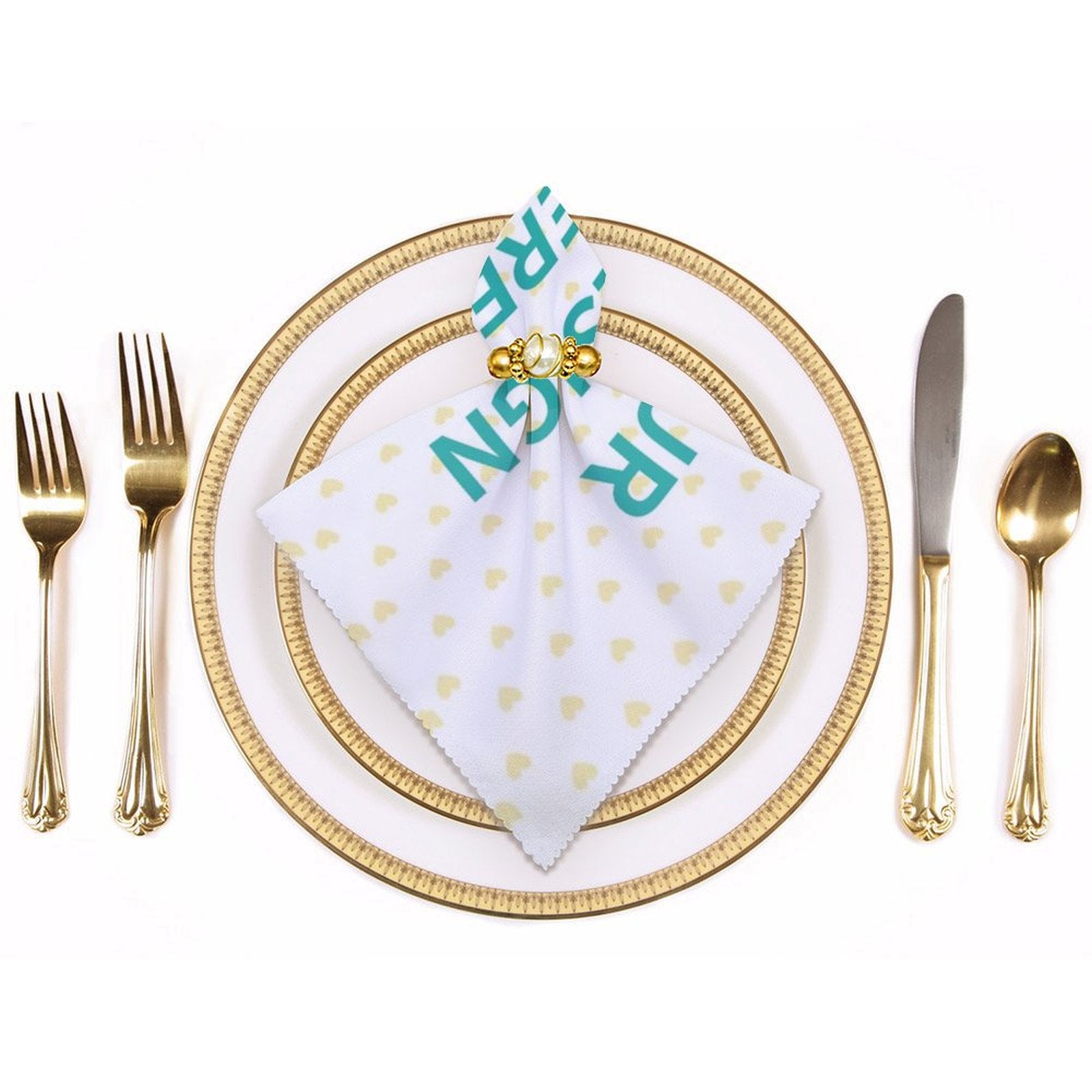 Personalized table napkin with JR text and heart pattern, part of elegant table setting with gold cutlery and plates.