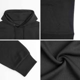 Black hooded sweatshirt close-up details: hood, pocket, cuff, and fabric texture. Cotton blend hoodie.