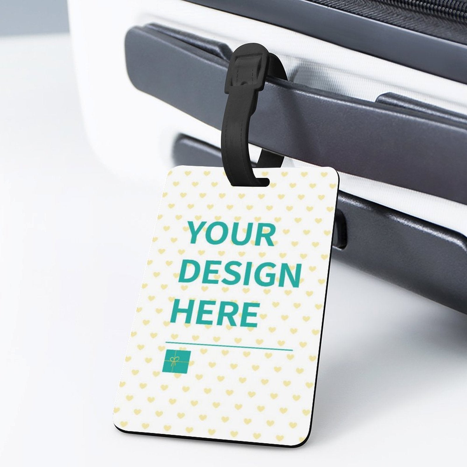 Customizable luggage tag with 'YOUR DESIGN HERE' on a suitcase. Made of TPU with a black strap; perfect for travel.