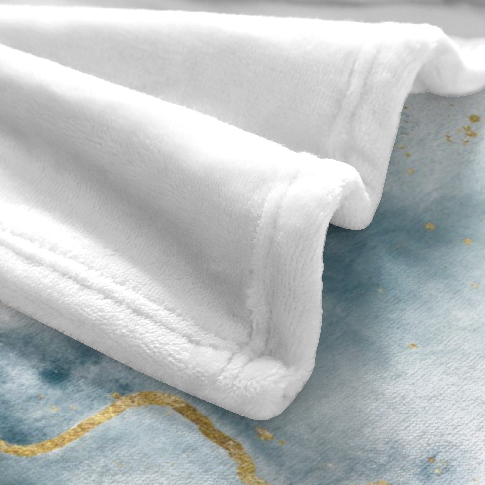 Soft white flannel blanket with blue abstract flow and gold accents, cozy and warm.