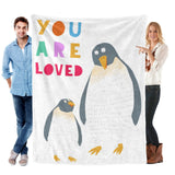 Kids Penguin Blanket. White flannel blanket featuring two penguins with the text "YOU ARE LOVED". Super soft and comfortable.