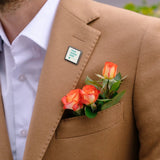 Custom alloy lapel pin with 'YOUR DESIGN HERE' on tan blazer, personalized design for shirt or jacket. Featuring orange roses