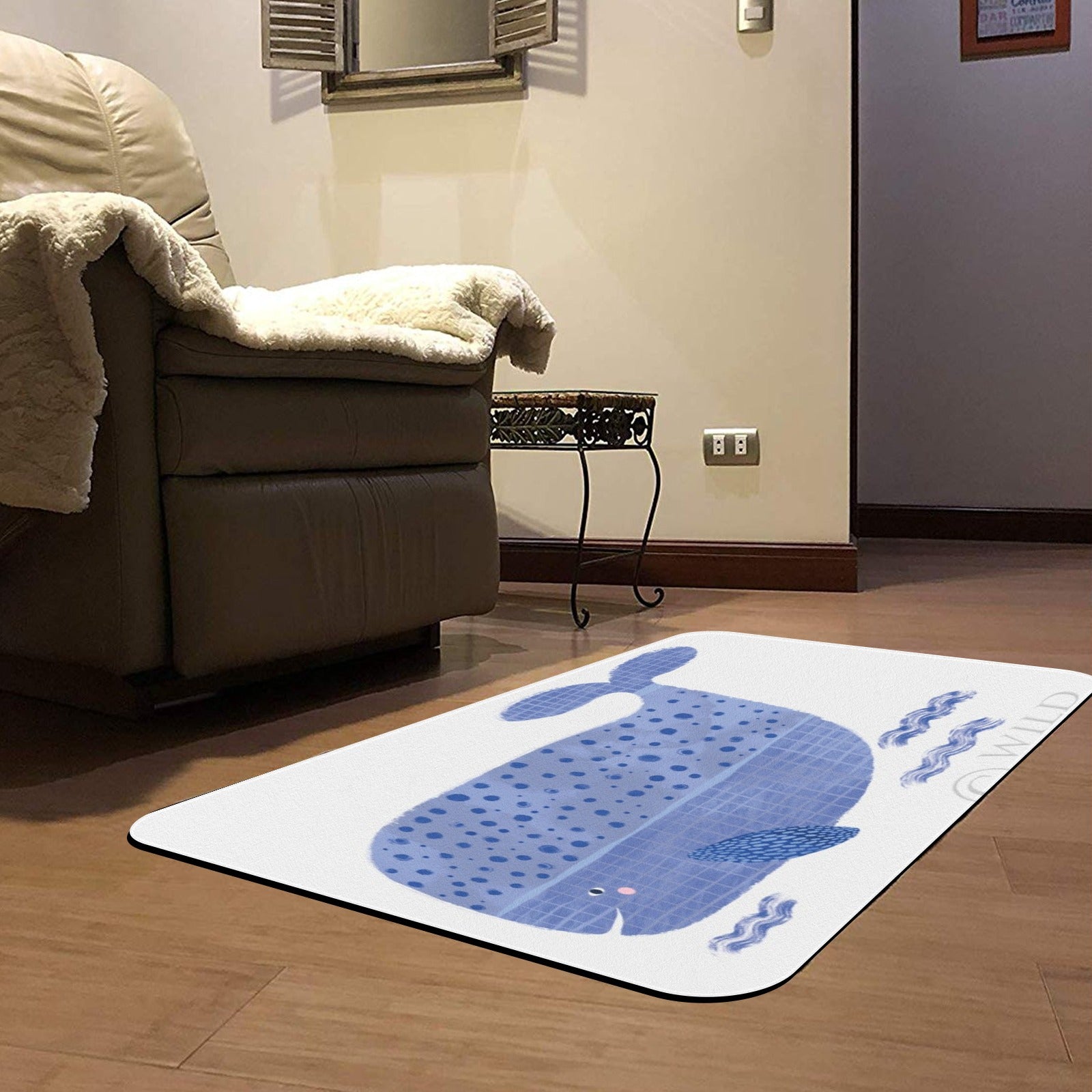 Blue whale door mat on hardwood floor. Decorative whale with wild text on white rug for home.