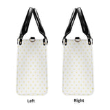 Personalized tote bag with yellow heart pattern, black handles, and adjustable strap; perfect for work or travel.